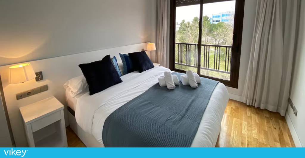 Dormitorio luminoso en un apartamento LiveTheCity en Madrid con cama doble y vistas al exterior.
