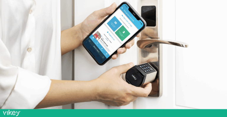 Mani che aprono una porta con serratura elettronica usando uno smartphone con app di accesso digitale.