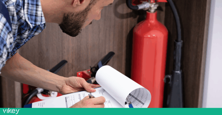 Tecnico che controlla estintori e compila un modulo di manutenzione antincendio in una struttura ricettiva